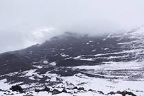 Камчатка Вулкан Толбачик и чёрное пространство рядом Снег и шлак